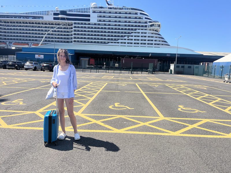 Girl with case getting ready to board cruise ship